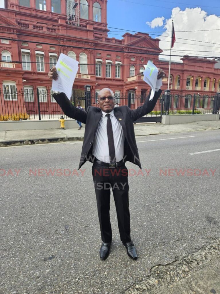 Wendell Eversley, deputy political leader of the Congress of the People, stands in front of the Red House on December 28, holding up a copy of the party’s constitution and a letter from interim political leader Prakash Ramadhar requesting reports on the party. - Photo by Janelle De Souza