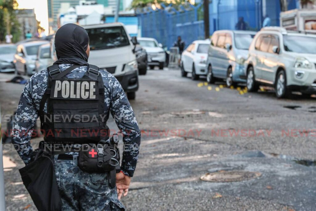 Police secure the scene of a fatal shooting on Besson Street, Port of Spain, on December 28. - Photo by Faith Ayoung