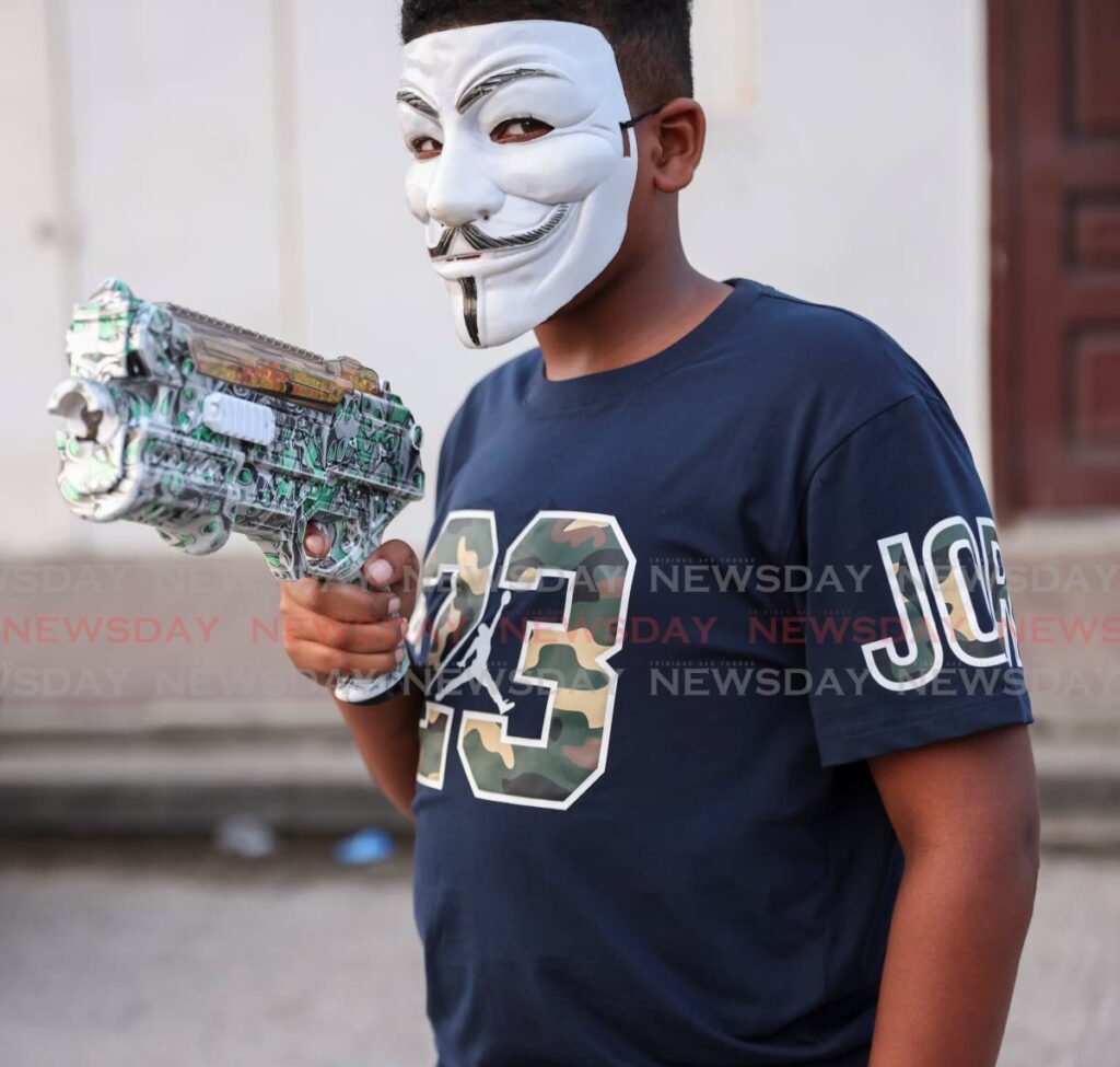 READY TO PLAY: A young man from Beetham Garden in a Guy Fawkes mask with his gel gun on December 29. - Photos by Jeff K Mayers