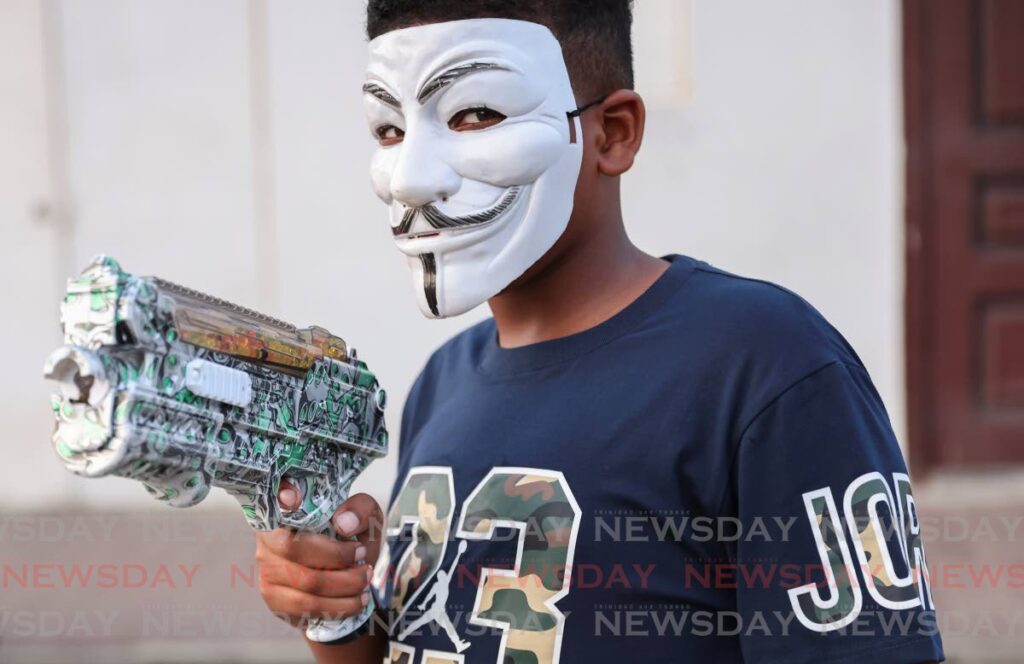 READY TO PLAY: A young man from Beetham Garden in a Guy Fawkes mask with his gel gun on December 29. - Photo by Jeff K Mayers