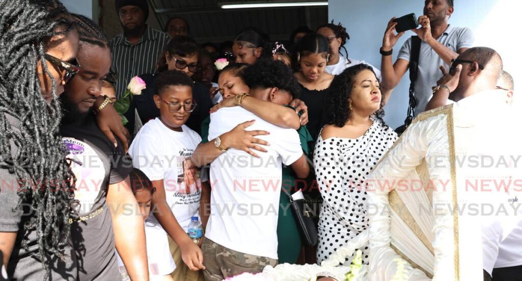 TEARS FOR STACY: Relatives console each other at the funeral of Stacy Gopaulsingh  who was murdered  on December 23. The funeral was held at the St Joseph RC Church, St Mary’s Village Moruga.  - Photo by Lincoln Holder