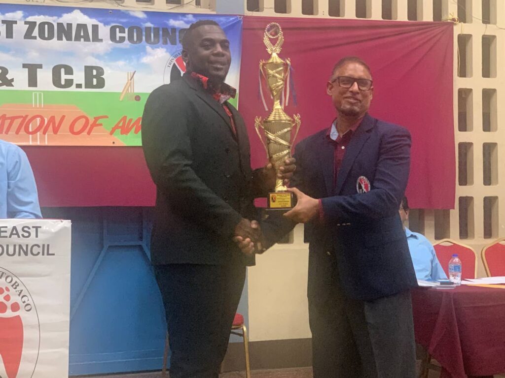 Altaf Baksh, left, secretary of the TT Cricket Board, presents the trophy for North East Zone Club of the Year, won by Rovers Sports and Cultural Club, at Guaico Government Primary School. - 