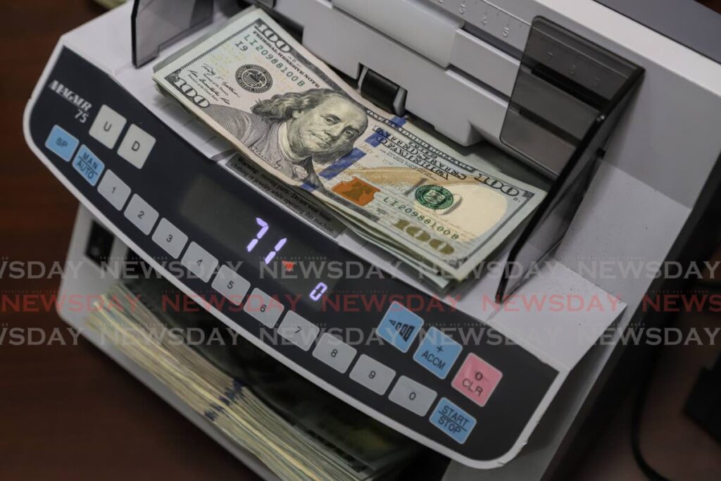 US dollar notes go through a money counter. - File photo by Jeff K Mayers