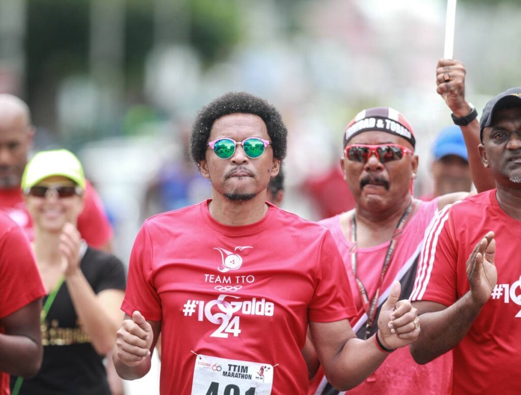 Former TTOC president Brian Lewis (centre) appraoches the finish line of the 2018 T&T international marathon. - File photo