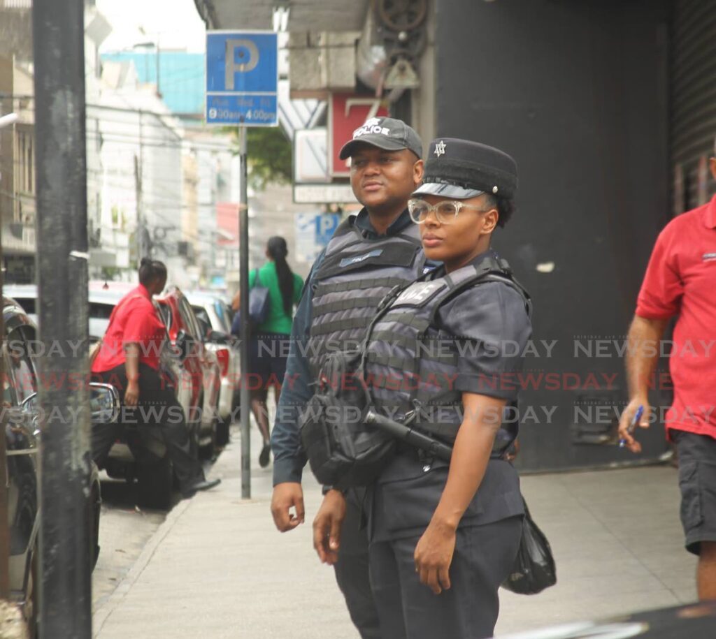 Constable Pierre and WPC Webb attached to the Capital City Patrol Unit (CCPU) out on patrol to direct vehicular and pedestrian traffic and deter criminals from downtown Port of Spain at Charlotte Street on April 2. - Photo by Faith Ayoung