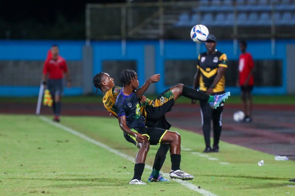 (FILE) St Benedict’s College player Derrel Garcia (back) tries to keep the ball in play while under pressure from a Signal Hill Secondary player during the SSFL Boys Intercol semifinal at the Ato Boldon Stadium on November 29, 2024 in Balmain, Couva. Photo by Daniel Prentice. - 