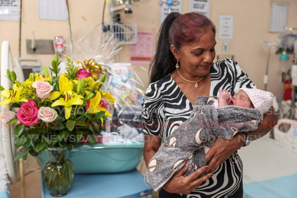 Taradai Harrypersad proudly holds her newborn granddaughter Diara Alexa Sandy Mohammed at the Mt Hope Women's Hospital on New Year’s Day. - Photo by Jeff K Mayers