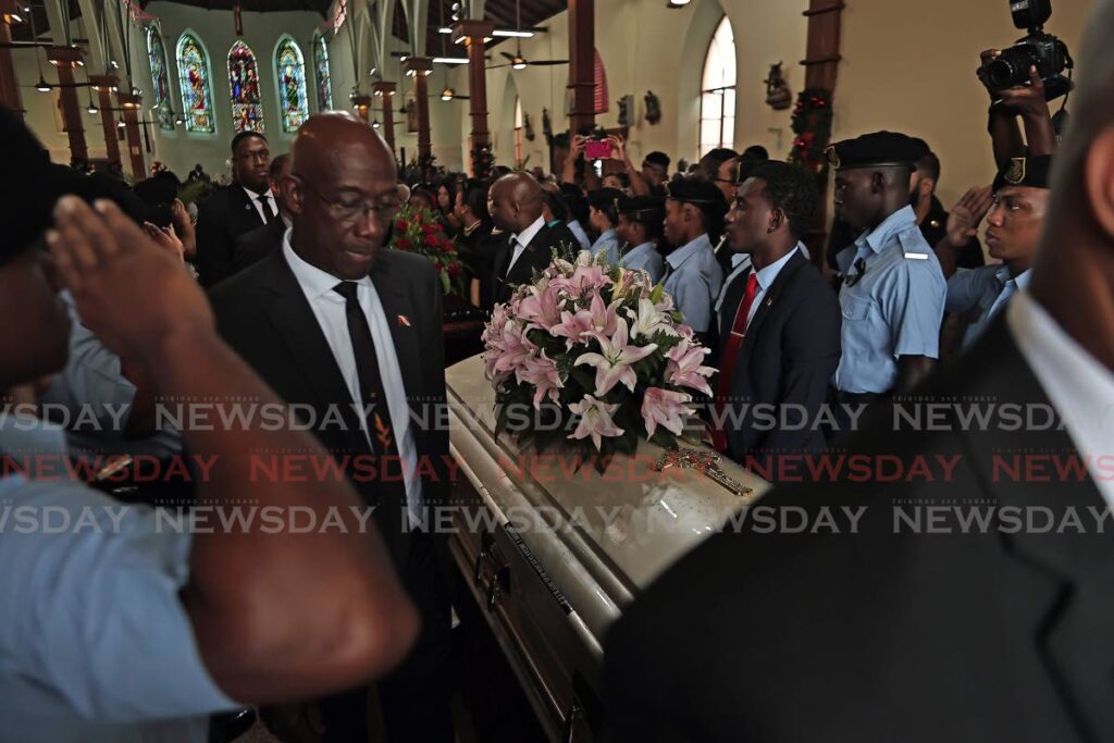 Prime Minister Dr Keith Rowley walks beside the caskets of D'Abadie/O'Meara MP and Minister in the Ministry of Education  Lisa Morris-Julian and two of her children at their funeral, held at the Santa Rosa RC Church, Arima on January 2. - Photo by Lincoln Holder 