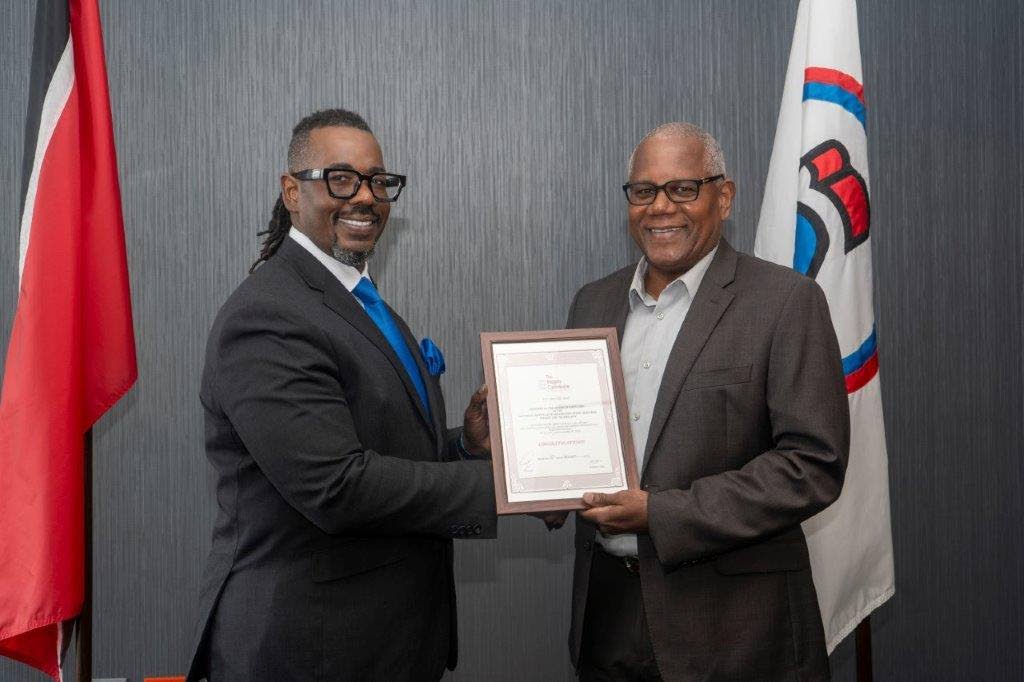 Haydn Gittens, chairman of the Integrity Commission (right) presents an award to Dr. Andrew Hunte, chairman of the NIHERST board of governors (left) for achieving 100 per cent compliance in the filing of declarations and registrable interests for the year ending December 31, 2023. - Photo courtesy NIHERST 