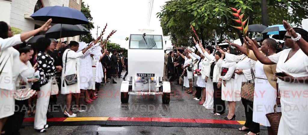 BALISIER SEND-OFF: Mourners wave Balisier flowers, the symbol of the PNM, as the coffins of D’Abadie/O’Meara MP Lisa Morris-Julian and her two children leave the Santa Rosa RC Church in Arima en route to the nearby cemetery on January 2. - Photo by Lincoln Holder