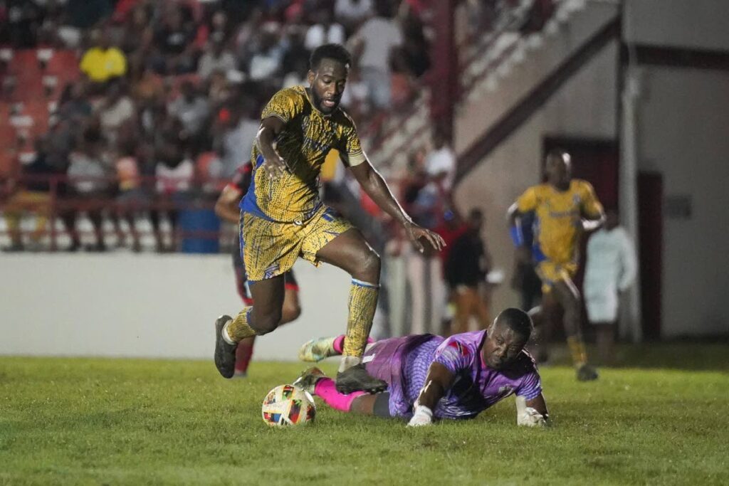 Defence Force skipper Kevin Molino dances past AC PoS goalkeeper Marvin Phillip during their TT Premier Football League match at the Phase 2 La Horquetta recreation ground on January 3. - Photo courtesy Defence Force