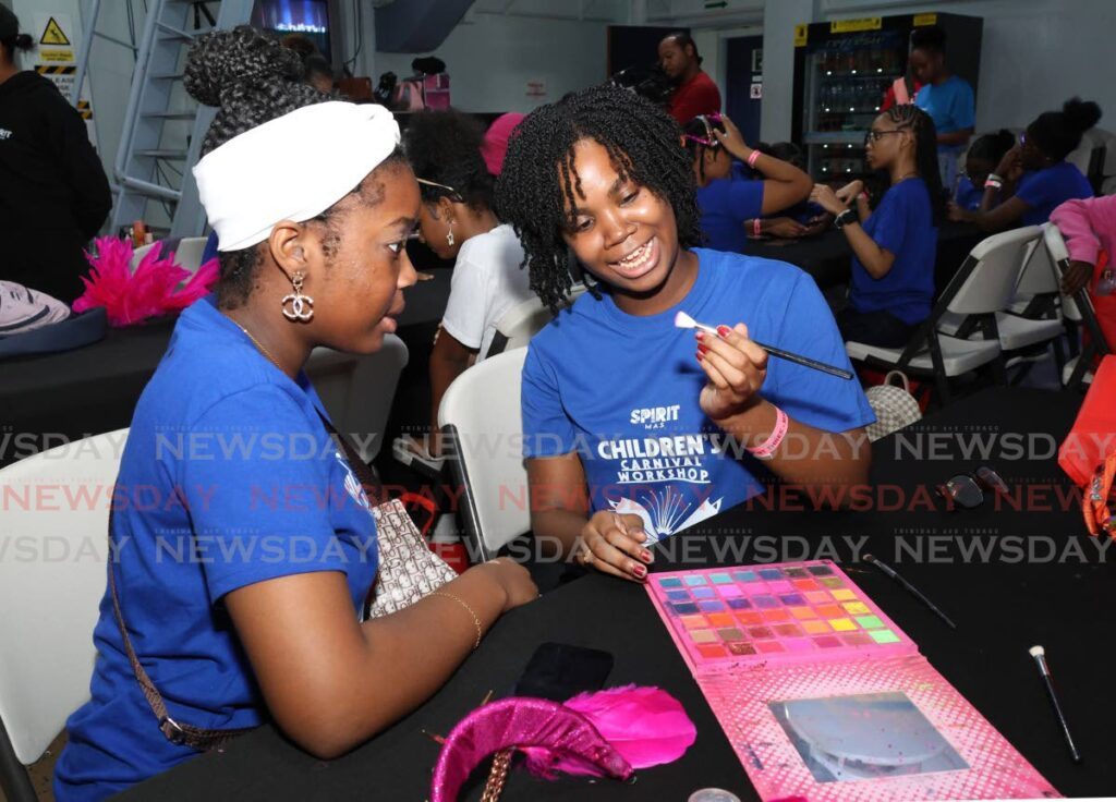 Kamilah Baptiste, left, and Dejourie McNeilly apply make-up to each other's face during the make-up class session. - Photos by Faith Ayoung