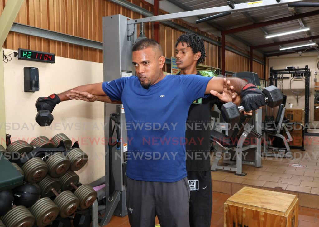 Dimitri Ross Jagroo goes through a set of lateral lifts with the help of Rafael Morange, physical therapy assistant at the Evolution Fitness Laboratory, at Pentecostal Road, Tunapuna on January 5. - Photos by Faith Ayoung