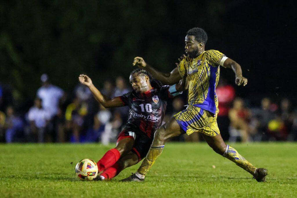 Defence Force FC captain Kevin Molino (R) tries to skip past a crunching tackle from AC Port of Spain's Duane Muckette during the TTPFL match at the Phase 2 Recreation Ground on January 3, 2025 in La Horquetta. - Photo by Daniel Prentice