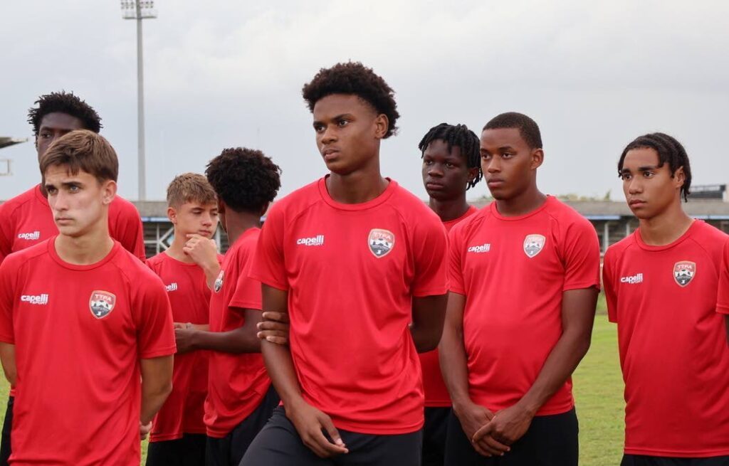 Paying close attention: TT men's under-17 footballers listen to coach Shawn Cooper during a training session at the Ato Boldon Stadium, Couva.  - TTFA Media