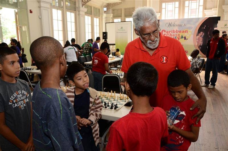 In this file photo, the late Kenneth Fitzpatrick is seen interacting with young players at the Caribbean Chess Carnival tournament. A junior chess tournament will be held in Fitzpatrick's honour at St Mary's College on January 11.   - Photo via TT Chess Association