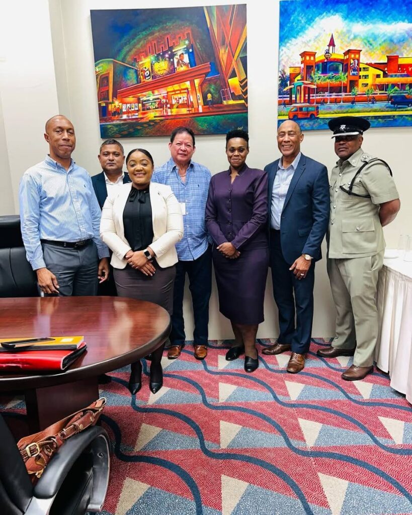 Derek Chin, centre, stands with DCP Suzette Martin and other TTPS officers during conversations during the Christmas season. -