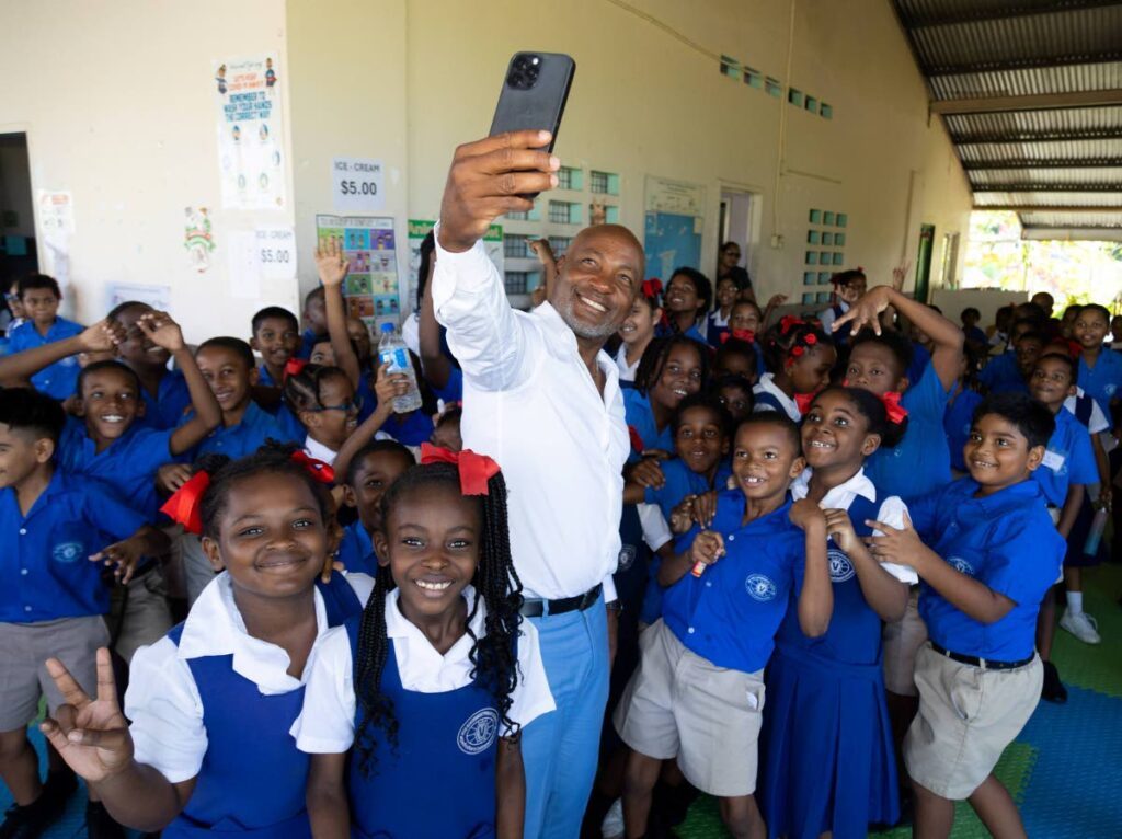 Cricket legend Brian Lara takes a selfie with students of at VOS Government Primary School recently.  - 