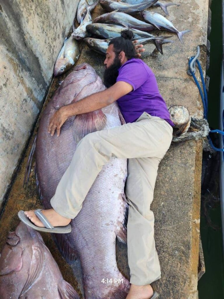 Varoon Boodram next to a 330-pound Warsaw Grouper he caught with a group of friends off the North coast on January 12.  - 