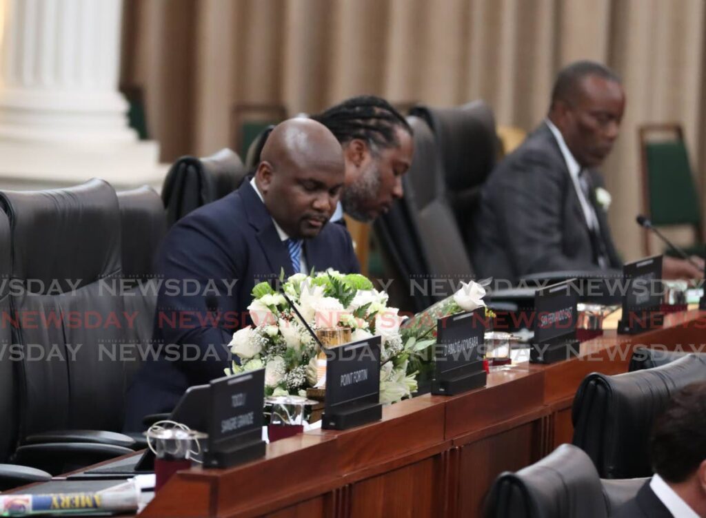 San Fernando East MP Brian Manning sits next to a bouquet of white flowers that was placed on the empty desk of late Arima MP Lisa Morris-Julian in the House of Representatives at Parliament on January 13 in her memory. Morris Julian died along with two of her children in a fire at her Arima home on December 16. - Photo by Angelo Marcelle