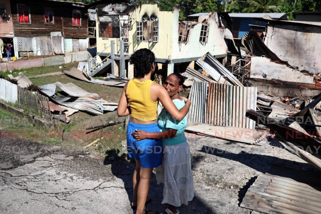 A relative embraces Rasheeda Mohammed, right, who lost her home in the January 14 fire. - Photo by Lincoln Holder 