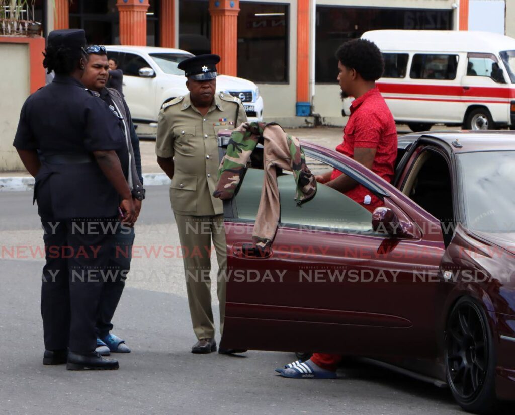 Police question a driver on during at the Eastern Main Road, Golden Grove Road, Arouca intersection on January 14. - Angelo Marcelle