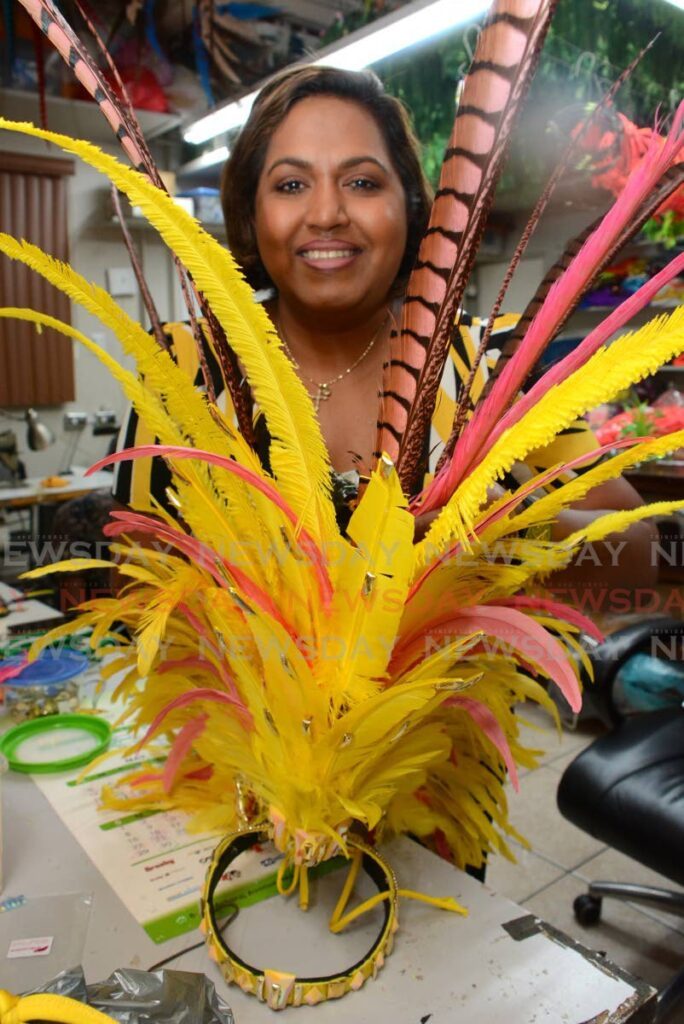 Ayana Kalicharan-Mahase, bandleader of Kalicharan Carnival makes some final adjustments to a headpiece, from the section Lemonade in 2025 mas band presentation Aroma at the band's Harris Street location on January 15. - Photo by Innis Francis