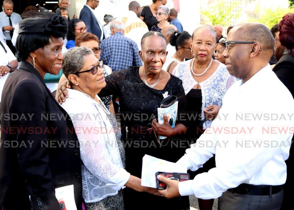 Melba Madeira is greeted by journalist Dale Enoch after her husband Jones P Madeira's funeral on January 16. - Photos by Ayanna Kinsale