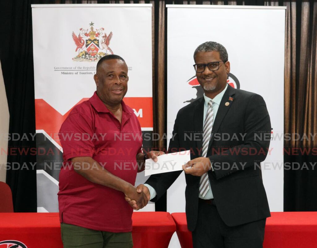 Andre Franco, left, San Juan East Side Symphony bandleader, receives a cheque from Martel Waldron, deputy permanent secretary of the Ministry of Tourism, Culture and the Arts at the Pan Trinbago cheque distribution ceremony for 149 unsponsored steelbands at VIP Lounge, Grand Stand, Queen's Park Savannah, Port of Spain on January 16.  - Photos by Faith Ayoung