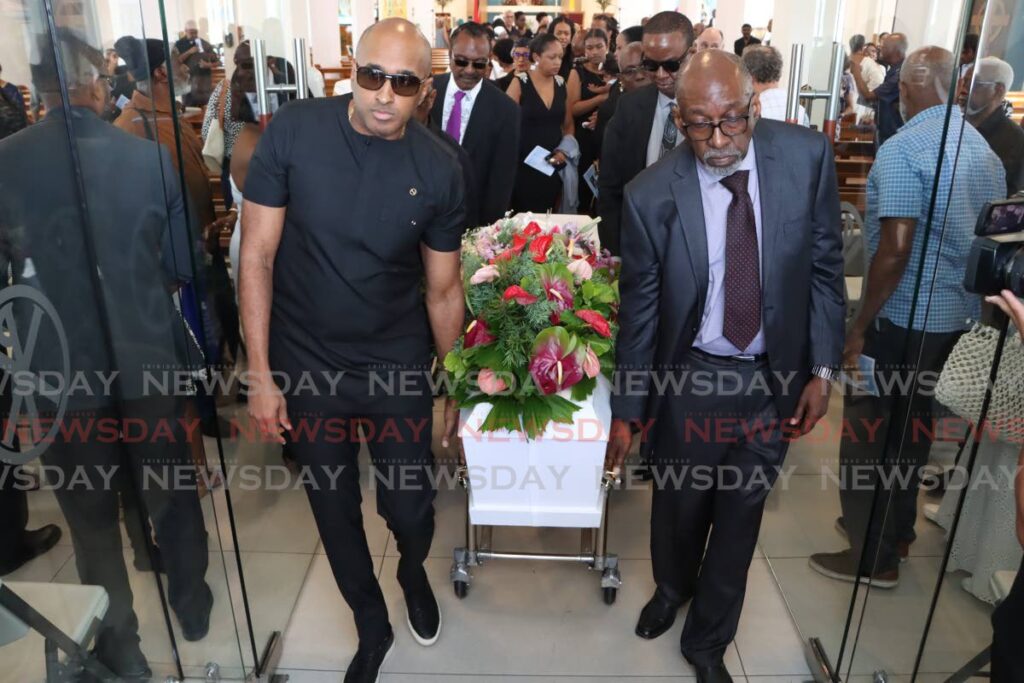 Friends and relatives of musician Roger Boothman carry his casket, at St Mary's Church, St James on Saturday.  - Photo by Angelo Marcelle