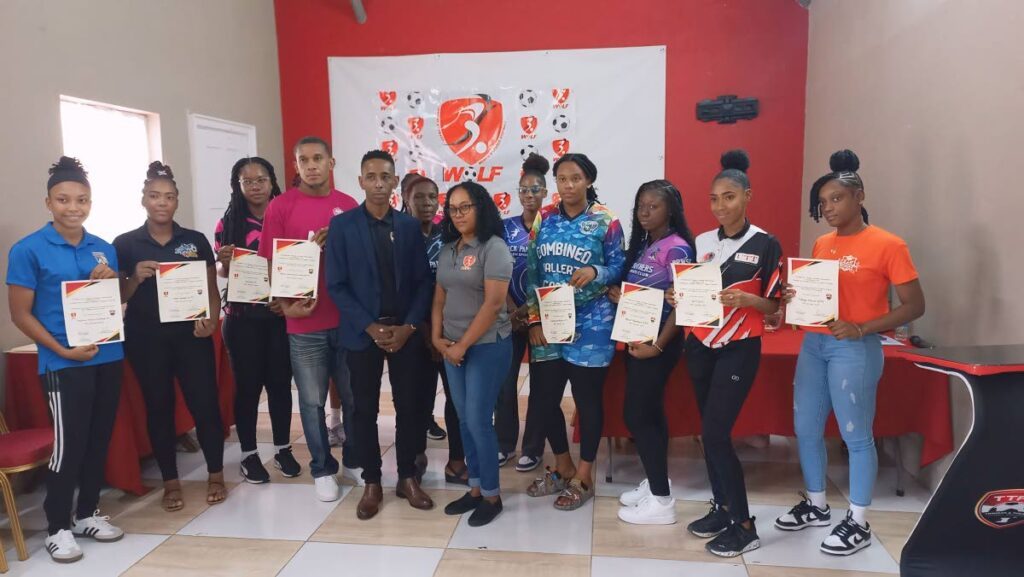 TT Women’s Football League (WoLF club representatives display their TT Football Association (TTFA) certificates of compliance distrubuted by TTFA third vice-president Jameson Rigues (front left) and WoLF executive member Lystra Lara (front right) during the 2025 WoLF season launch, on Saturday, at the TTFA Technical Centre, Couva.  - Photo by David Scarlett