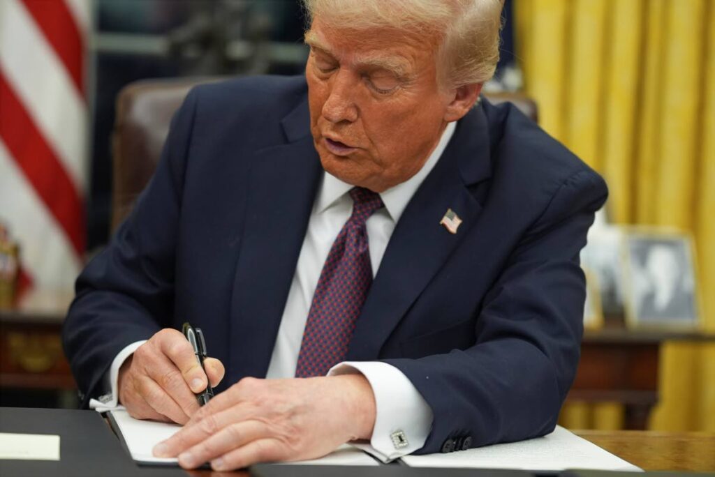 US President Donald Trump signs an executive order  in the Oval Office of the White House in Washington. - AP Photo