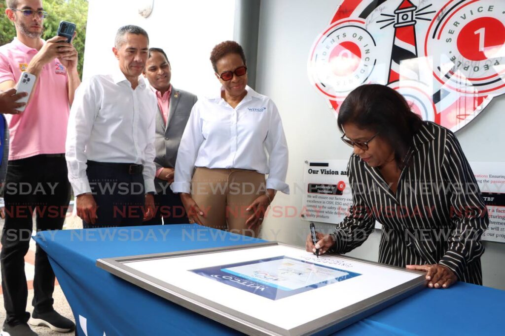 Trade Minister Paula Gopee-Scoon signs Witco's three year no injury plaque, before a tour of the compound in Champ Fleurs on Friday.  - Photo by Angelo Marcelle