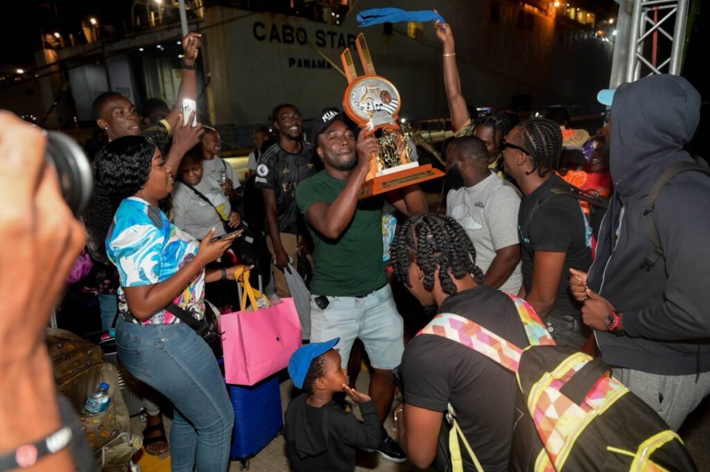 OH YES!: Arranger Kersh Ramsey lifts the Panorama small conventional bands trophy alongside members of T&TEC New East Side Dimension, during a welcome ceremony on January 26 at the Port of Scarborough after the band defended its title in the national finals in Trinidad.  - Photo by Visual Styles 