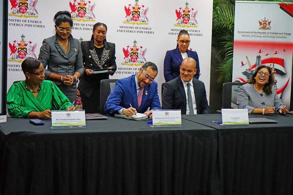 ENERGY Minister Stuart Young (centre, seated) signs the award of two production-sharing contracts to EOG Resources Ltd, watched by EOG head George Vieira (second right, seated) and other ministry and EOG officials. - Photo courtesy Energy Ministry 