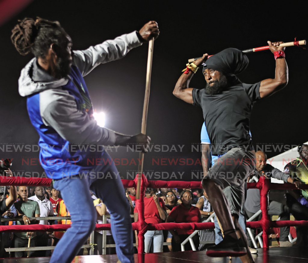 From left, stickfighter Anthony Cooper defends against Ronald Lewis during the preliminary round of the NCC National Stickfighting competition held at the Moruga Multi-Purpose Youth and Sport Facility on February 14. - Photo by Lincoln Holder