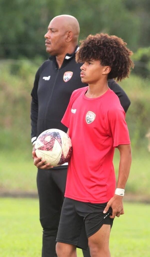 (FILE) TT men’s Under-17’s Dominic Joseph stands alongside coach Shawn Cooper during a training session at the Ato Boldon Stadium, Couva.  - TTFA