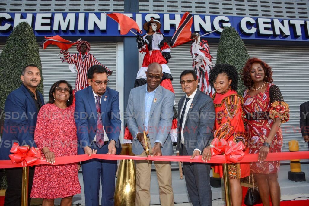 Dr Rowley cuts the ribbon to officially open the new Gran Chemin Fishing Centre on January 31. From left are Senator Avinash Singh, Trade Minister Paula Gopee-Scoon, Agriculture Minister Kazim Hosein, Works and Transport Minister Rohan Sinanan, Education Minister Dr Nyan Gadsby-Dolly and Social Development Minister Donna Cox.  - Photo by Innis Francis