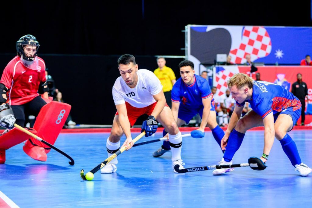 Jordan Vieira of Trinidad and Tobago passes the ball while under pressure against Namibia in the Indoor Hockey World Cup in Croatia. - FIH