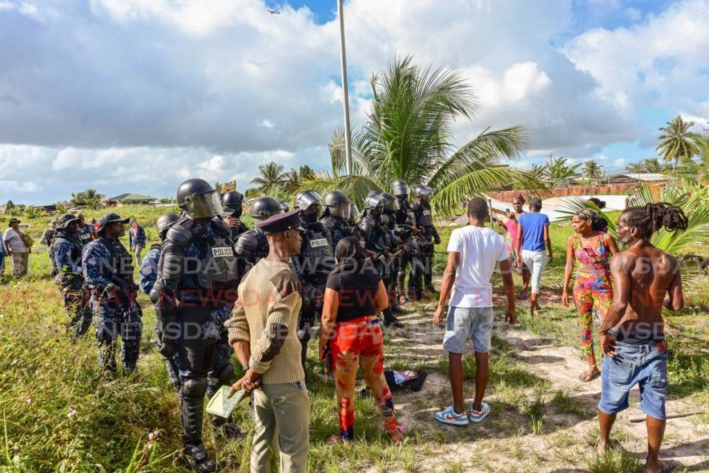 Residents of Ramjattan Trace, Arima, face off with police on February 6 as their illegally constructed homes were demolished by order of the Commissioner of State Lands. - File photo 