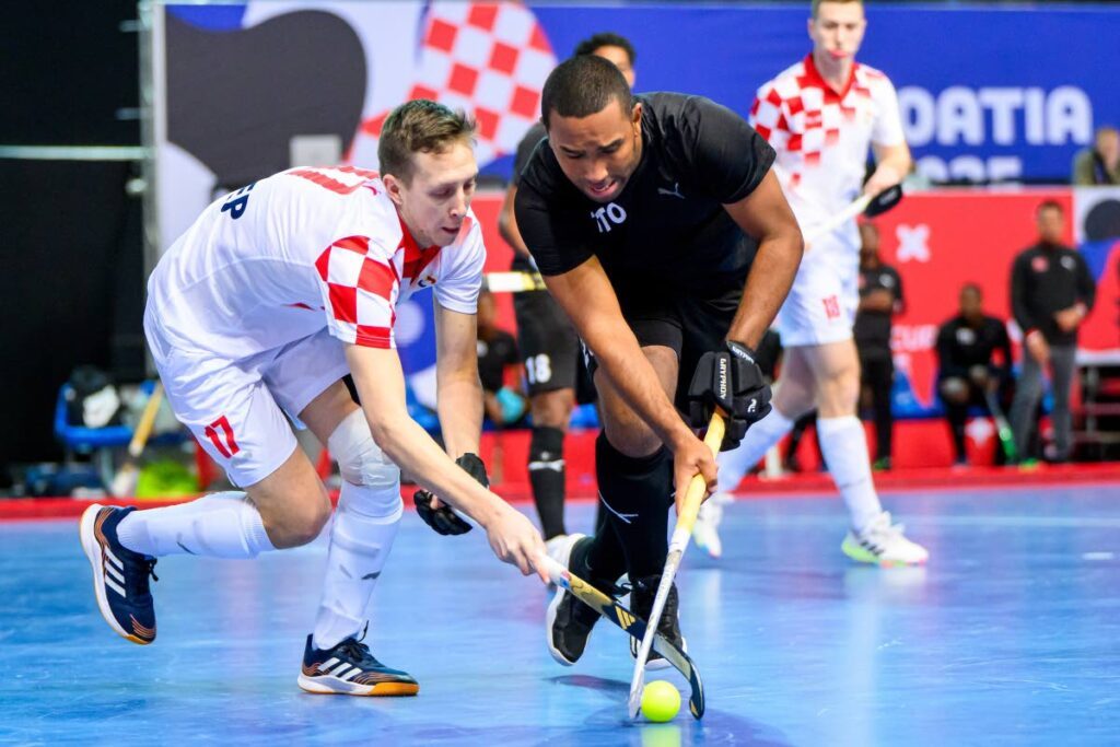 Jordan Reynos of Trinidad and Tobago, right, is tackled by Mario Ilinović of Croatia in the Indoor Hockey World Cup in Croatia on February 7.  - FIH