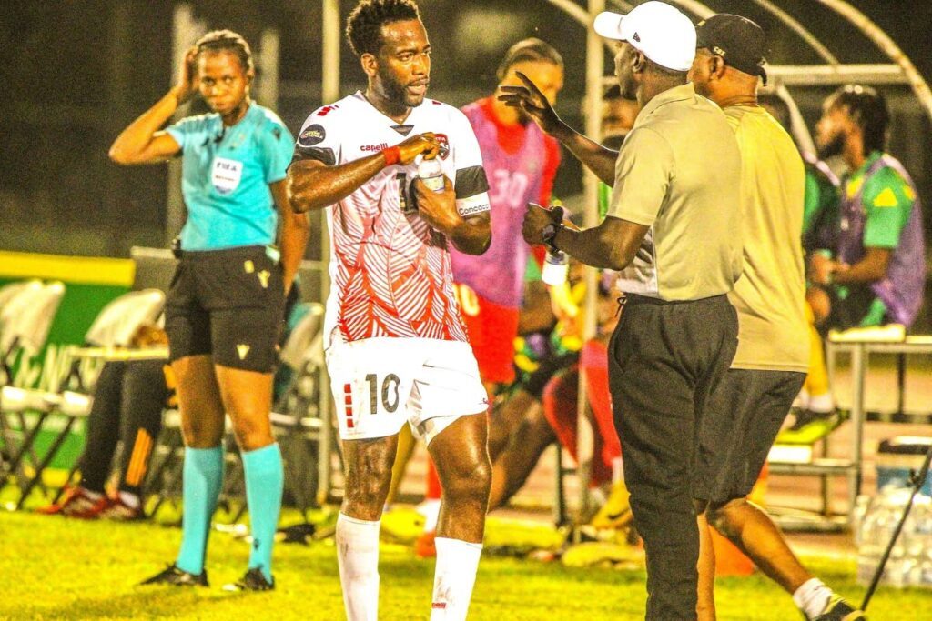 Soca Warriors coach Dwight Yorke and captain Kevin Molino discuss strategy during their team's friendly encounter with Jamaica at the Catherine Hall Sports Complex, Montego Bay on February 6. Photo courtesy TTFA  - 