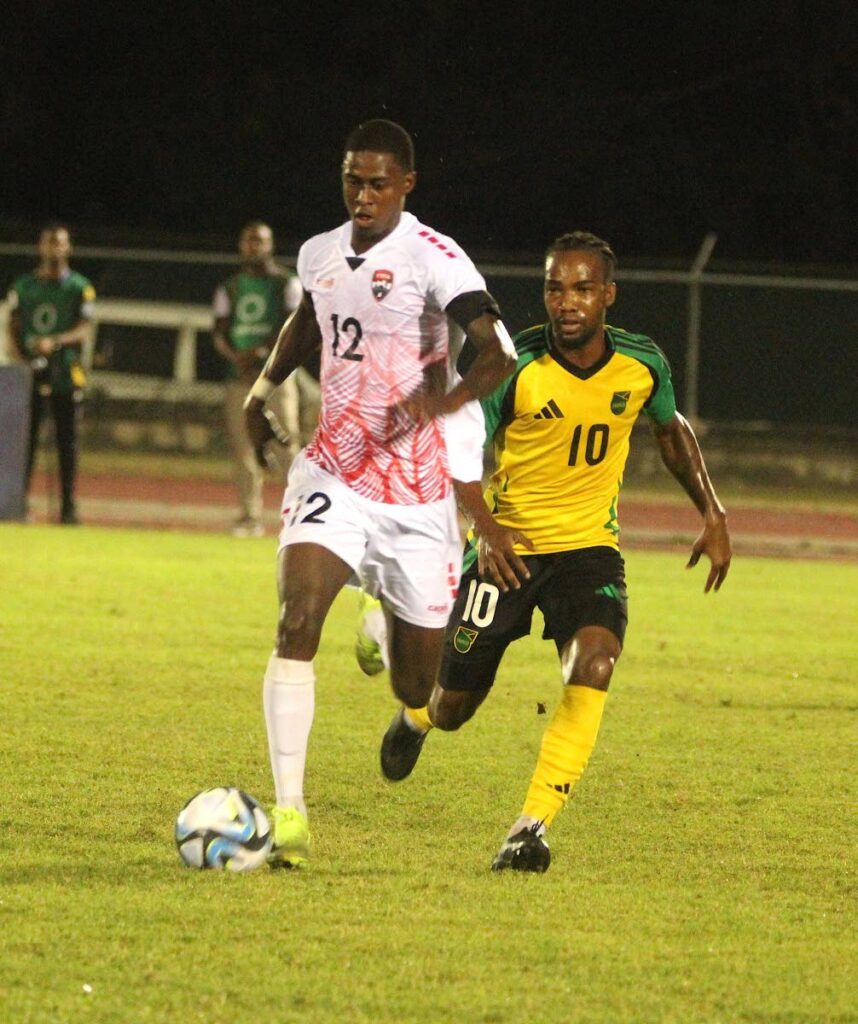 Trinidad and Tobago's Isaiah Lee, left, runs with the ball while tracked by Jamaica's Tyreek Magee in a football friendly at the Catherine Hall Sports Complex, Montego Bay, Jamaica, February 6. - Photo courtesy TTFA