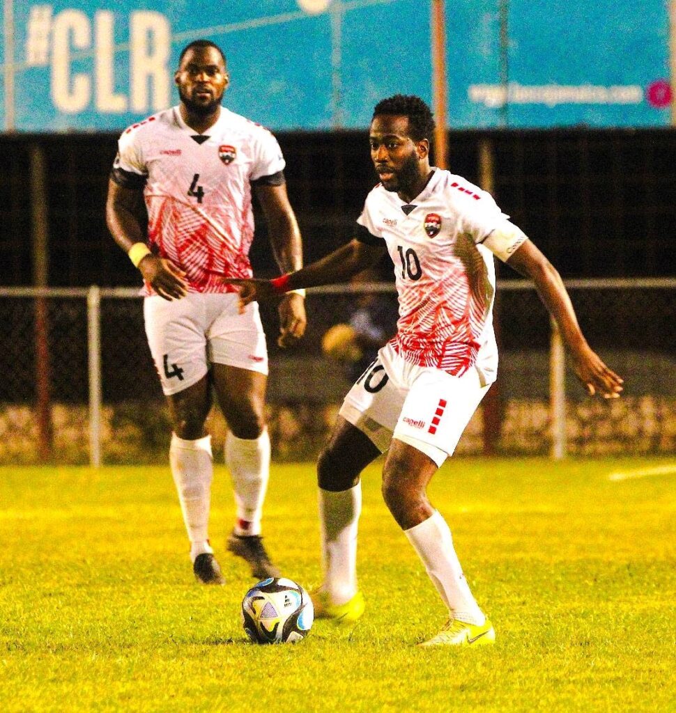 Playmaker Kevin Molino (R) looks for a passing option as Soca Warriors goal scorer Josiah Trimmingham looks on during a friendly international against Jamaica at the Anthony Spaulding Sports Complex, Kingston on February 9. Photo courtesy TTFA  - 