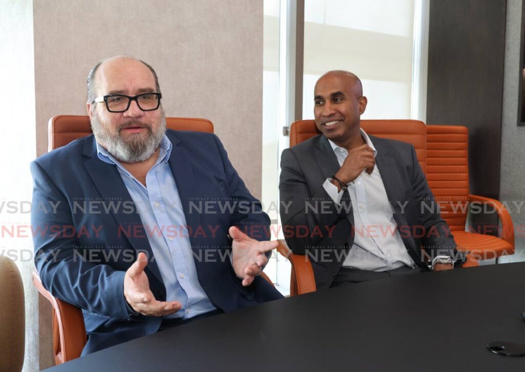 Massy Group CEO David Affonso, left, and CFO James Mc Letchie chat about the group's new business model. -  Photo by Faith Ayoung