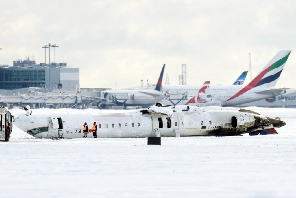 A Delta Air Lines plane lies upside down at Toronto Pearson Airport on  February 18. - (Chris Young/The Canadian Press via AP) 