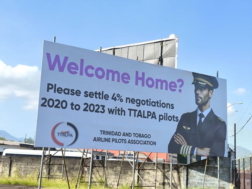 TT Airline Pilots Association (TTALPA) calls for a settlement a four per cent salary increase for 2020-2023 on a billboard on the western side of BWIA Boulevard, Piarco. - 