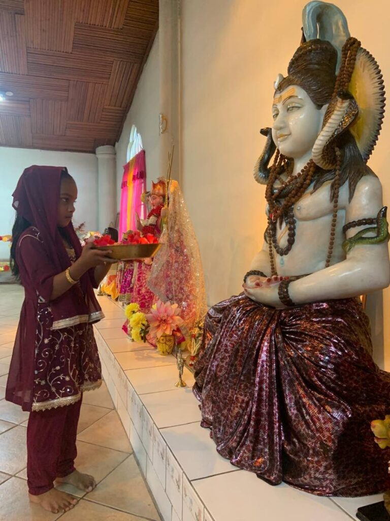 Six-year-old Parvati Rambaran pay to Lord Shiva. - 