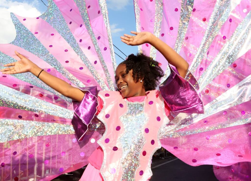 This masquerader from Zebapique Productions, Yuh Ever See, A Tribute to our Icons enjoys herself during the St James Children's Carnival parade along the Western Main Road, St James on February 23. - Photo by Ayanna Kinsale