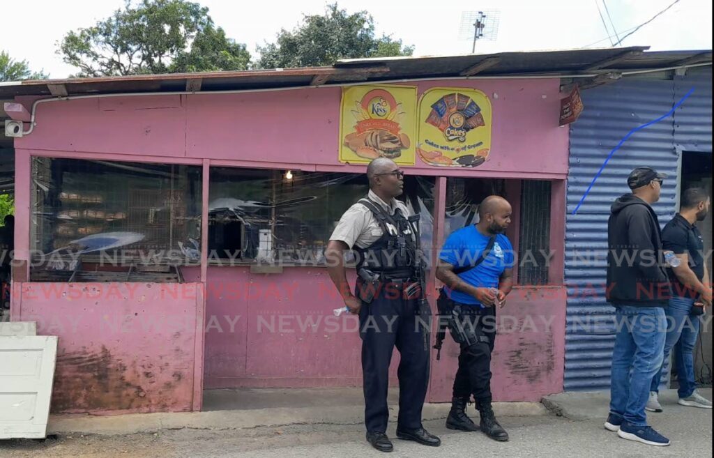 In this photo captured on February 22, police prepare to interview residents outside the parlour on La Retreat Extension Road where Anicia James, her common-law husband Mitchell Francois and her brother Anselm James were murdered on February 22. On March 14, two men were murdered and one injured following another ambush by gunmen - Photo by Gregory McBurnie 